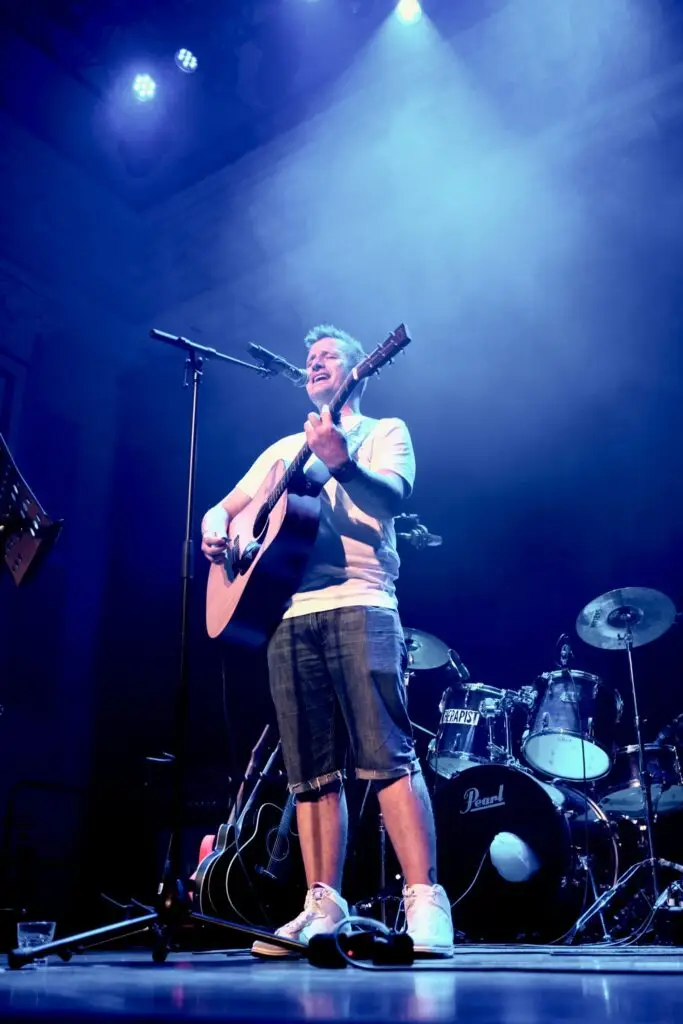 Ryan Kershaw singing and playing the guitar on stage