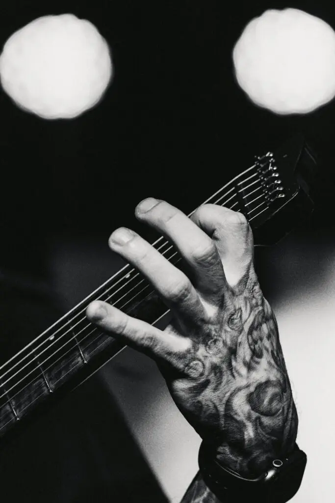 Black and white hand close-up of someone playing the guitar